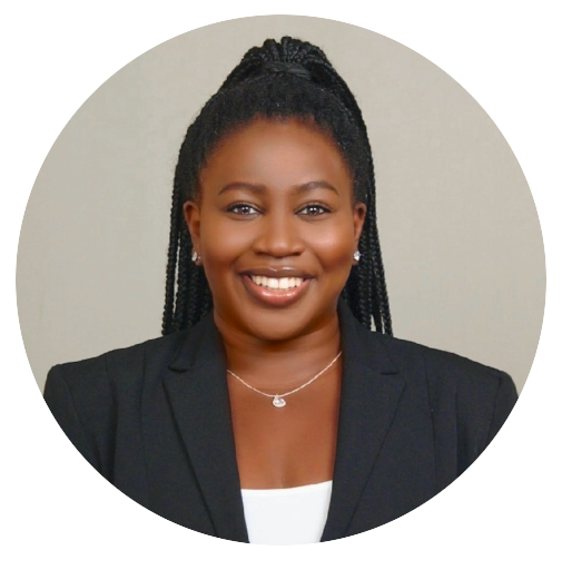 Andrea, smiling with long black cornrows wearing a black suit coat.