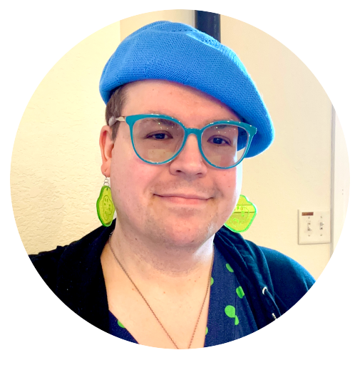 Cyndi, smiling with a blue beret and turquoise glasses.