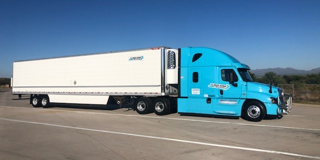 Turquoise cab with a refrigerated trailer.
